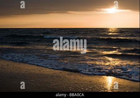 Wellen Waschen über Sand bei Sonnenuntergang, Scheveningen, Den Haag, Niederlande Stockfoto