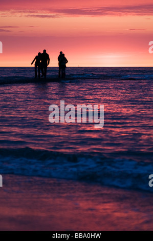 Paare, die den Sonnenuntergang am Strand von Scheveningen, Den Haag, Niederlande Stockfoto