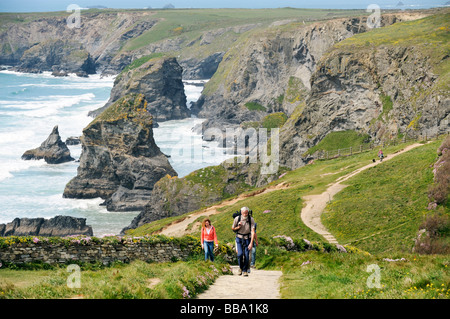 Küste Wanderer auf dem South West Coast Path nördlich von Newquay, Cornwall. Hintergrund der Felsnadeln und Klippen von Bedruthan Steps.