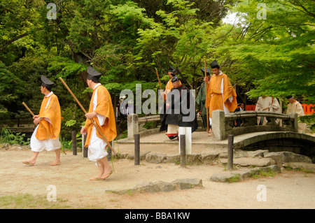 Shintoistic Priester und Reiter zu Fuß über eine Brücke im Kamigamo Schrein während einer Shintoistic Pferderennen in Kyoto, Japan Stockfoto