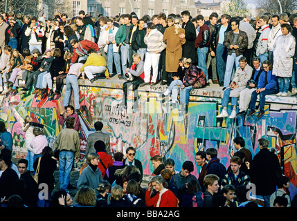 Menschen auf der Mauer am Brandenburger Tor, dem Tag nach dem Fall der Berliner Mauer, Berlin, Deutschland, Europa Stockfoto