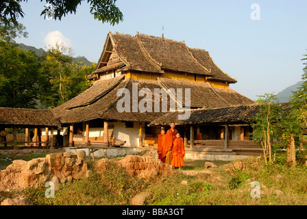 Buddhismus, Mönch mit zwei Novizen, tragen orangefarbene Gewänder, alten Tai-Lue Tempel Wat Luang, Ou Neua, Gnot Ou, Provinz Phongsali, Laos Stockfoto