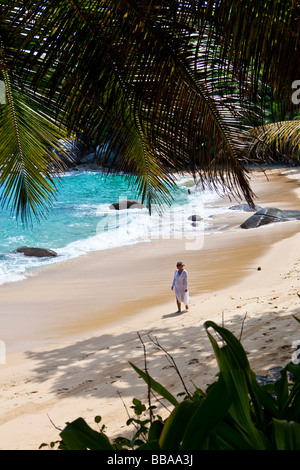 Frau am Strand entlang trägt eine Tunika, Insel Mahé, Seychellen, Indischer Ozean, Afrika Stockfoto