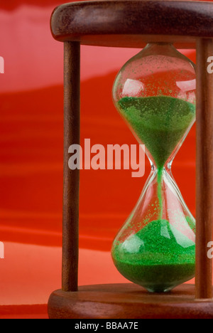 Nahaufnahme einer Sanduhr auf einem roten Hintergrund. Stockfoto