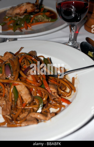 Pad Thai Chicken und Nudeln auf einem Teller mit Glas Wein. Stockfoto