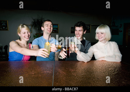 Vier Freunde, toasten Getränke an der bar Stockfoto