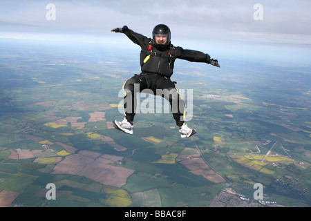 Fallschirmspringer in einer Position sitzen, während im freien Fall Stockfoto