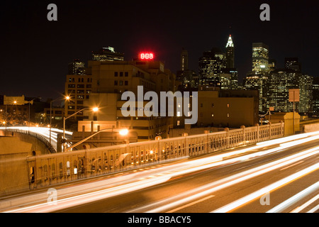 Schnellstraße auf der Brooklyn Bridge und Manhattan Skyline bei Nacht, New York City Stockfoto