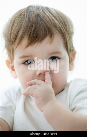 Ein kleiner Junge mit einem seiner finger-Nase Stockfoto