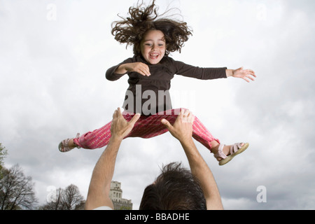 Ein Vater seine Tochter in die Luft werfen Stockfoto