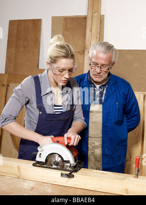 Ein Mann beobachtete eine Frau Holz Sägen Stockfoto