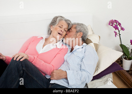 Ein senior Mann und ältere Frau zusammen auf einer Couch liegen Stockfoto