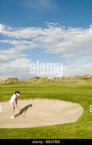 Ein Golfer spielt aus einem Sandbunker Stockfoto