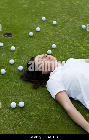 Ein erschöpft Golfer liegend auf einem Golfplatz Stockfoto