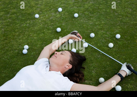 Ein erschöpft Golfer liegend auf einem Golfplatz Stockfoto