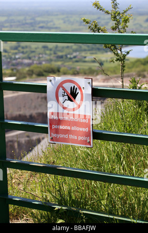 Warnschild am Rande eines offenen Steinbruchs platziert Stockfoto