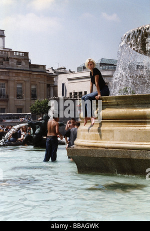Teenager erfrischen Sie sich in den Brunnen während einer Hitzewelle, Trafalgar Square, London, England Stockfoto
