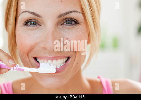 junge Frau, die sich die Zähne putzen Stockfoto