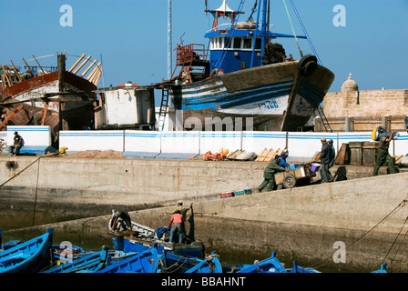 Traditionelle Fischerboote im Hafen und am Kai für Reparaturen, die weiße Stadt von Essaouira, Marokko, Nordafrika Stockfoto