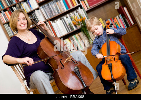 Schwangere und junge spielt Cello Stockfoto