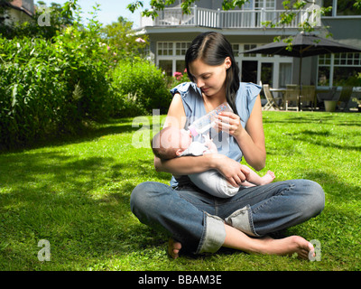 Mutter füttert ihr Baby im Garten Stockfoto