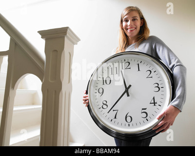 Frau beim Treppensteigen mit einer Uhr Stockfoto