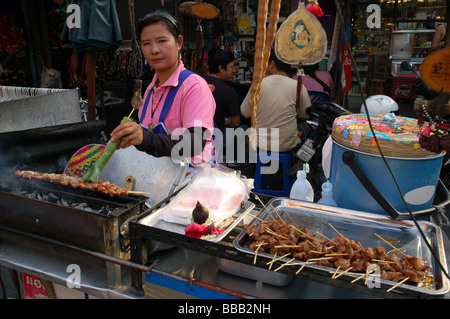 Thai Lady, Verkauf von gegrilltem Hähnchen-Sticks in Khao San Road, Bangkok, Thailand