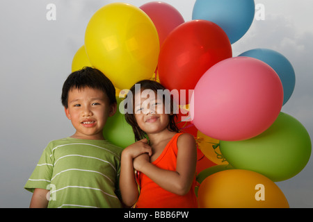 Jungen und Mädchen mit Luftballons. Stockfoto