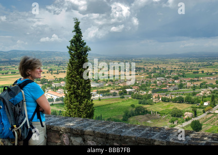 Eine Frau Tourist mit Rucksack Blick auf umbrischen Landschaft aus Sicht in Spello mit dunklen Wolken sammeln Stockfoto