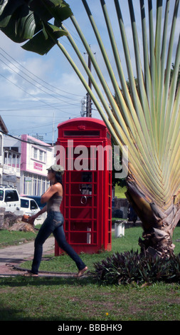 Frau geht vorbei an roten englischen Telefonzelle Unabhängigkeit Square Basseterre Hauptstadt St. Kitts Caribbean Stockfoto