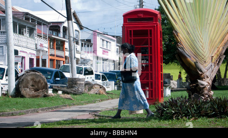 Frau geht vorbei an roten englischen Telefonzelle Unabhängigkeit Square Basseterre Hauptstadt St. Kitts Caribbean Stockfoto