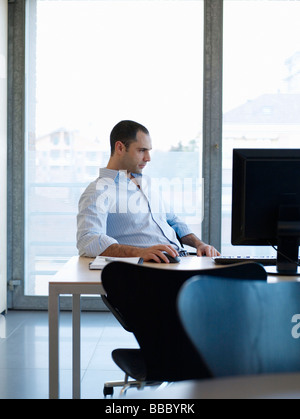 Junger Geschäftsmann am Schreibtisch Stockfoto