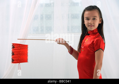 Junges Mädchen im traditionellen Kleid Chinesisch halten rote Laterne und Blick in die Kamera Stockfoto