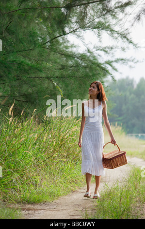 Frau mit Korb auf Landstraße Stockfoto