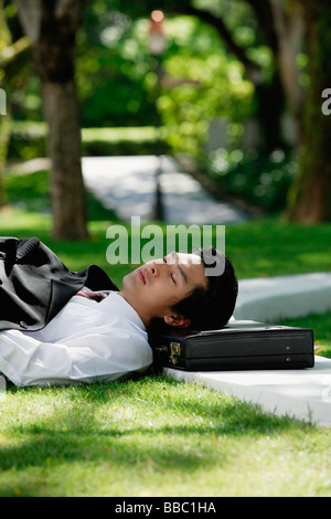 Ein Mann legt sich hin und hat eine Pause im park Stockfoto