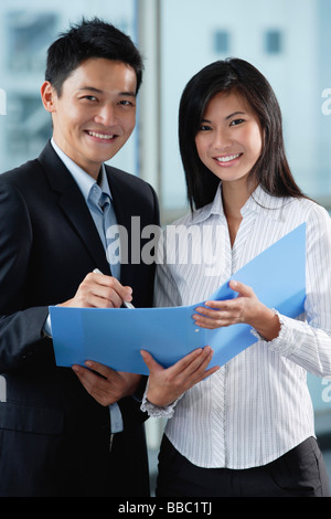 Zwei Arbeitskollegen Lächeln in die Kamera zusammen Stockfoto