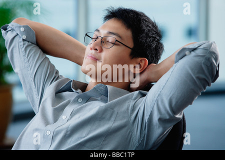 Ein Mann entspannt an seinem Schreibtisch Stockfoto