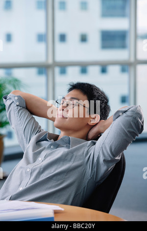 Ein Mann entspannt an seinem Schreibtisch Stockfoto