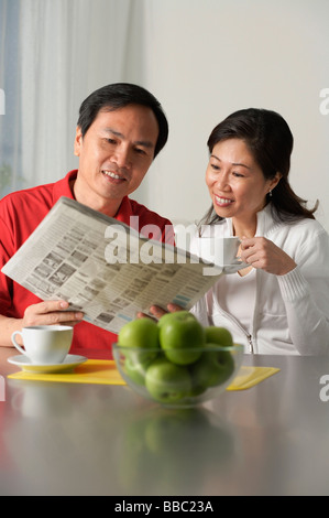 Älteres Paar auf der Suche bei Zeitung und Kaffee Stockfoto