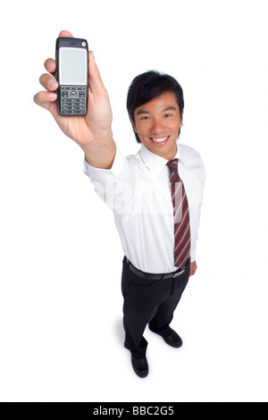 Ein Mann in die Kamera lächelt, als er aus seinem Handy hält Stockfoto