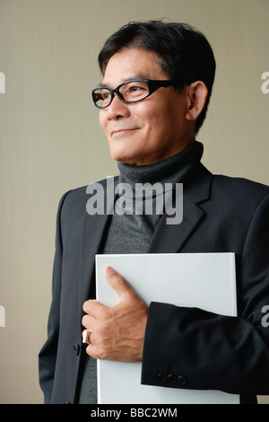 Ein Mann mit Brille mit einem weißen Ordner Stockfoto
