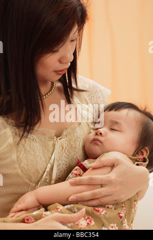 Mutter hält Babymädchen in die Arme, Baby schläft, Mutter Baby betrachten Stockfoto