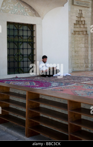 Ein bosniakischer Muslim, der in der Moschee von Gazi Hursev Bey im Distrikt Bascarsija, dem Marktsektor der Altstadt in Sarajevo, Bosnien, eine Zeitung liest Stockfoto