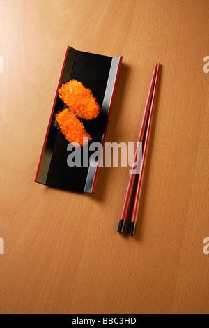 zwei Stücke von Sushi, Stäbchen, Tobiko Gunkan, Fischrogen Stockfoto