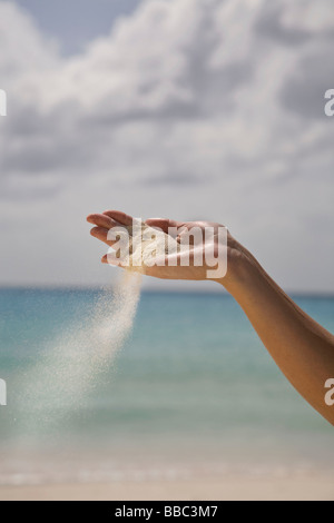 Sand fallen aus Frauenhand Stockfoto