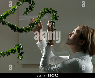 Frau angreifen Pflanze betrachten Stockfoto