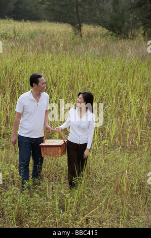 Mann und Frau zu Fuß durch die Natur mit Picknick-Korb Stockfoto