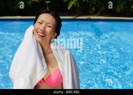 Frau, die sich mit einem Handtuch abwischen Schwimmbad im Hintergrund Stockfoto