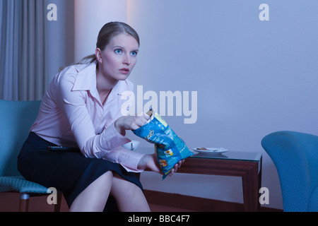 Frau im Hotelzimmer, vor dem Fernseher Stockfoto