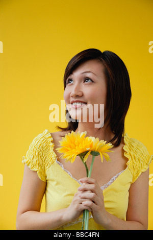 Junge Frau mit gelben Blüten, wegschauen Stockfoto